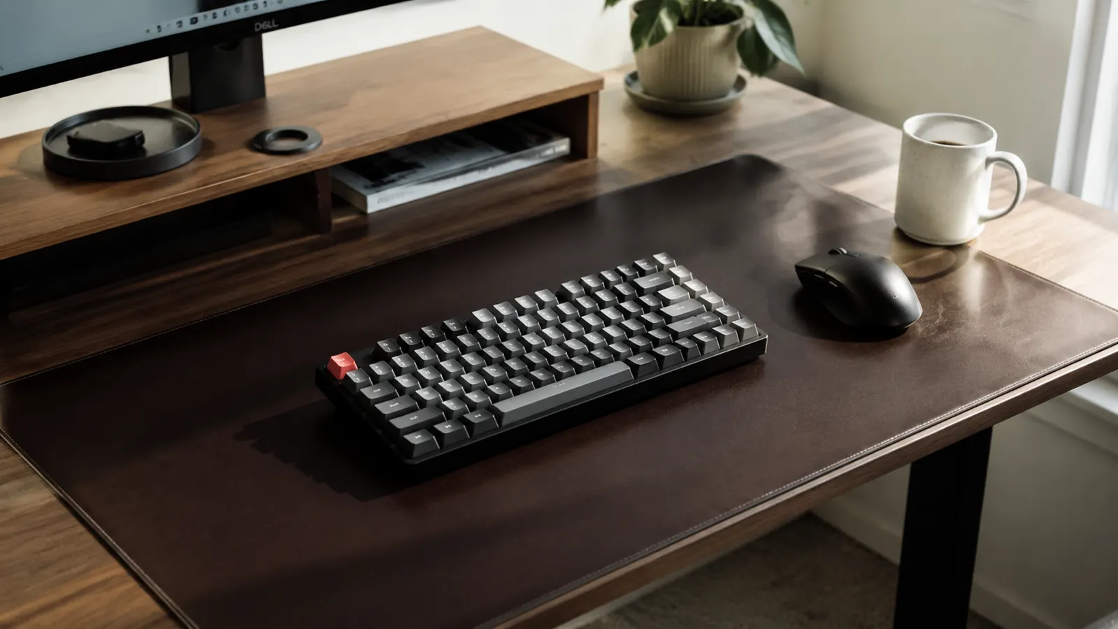 Close-up of an Aothia desk pad on a wooden desk with a keyboard, mouse, and coffee mug arranged on top, warm natural light from a window