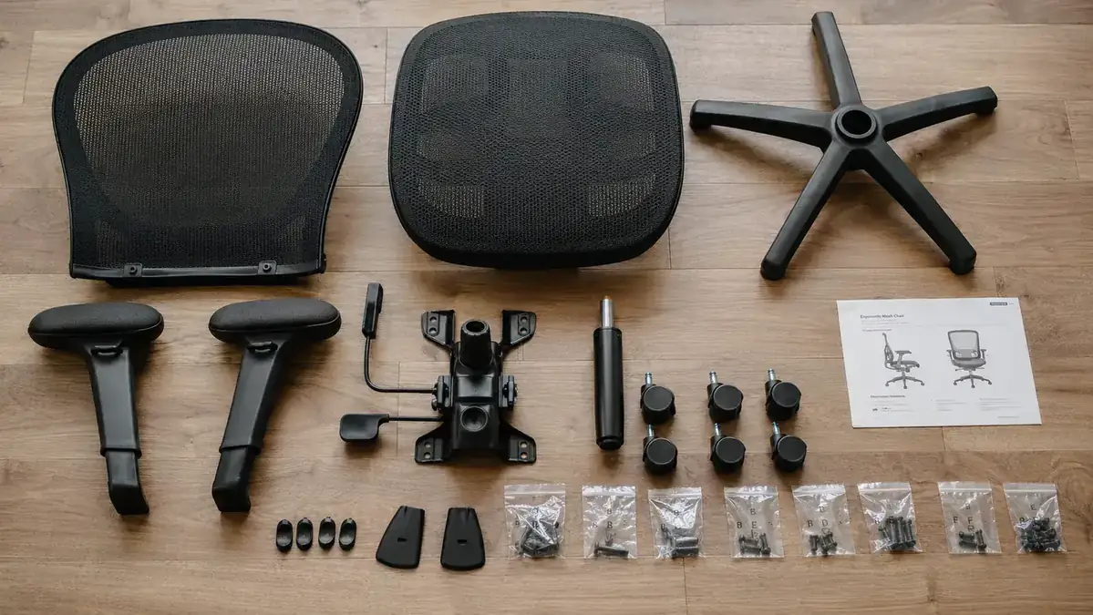 Flat-lay of GABRYLLY chair packaging contents spread across the floor showing all parts and hardware